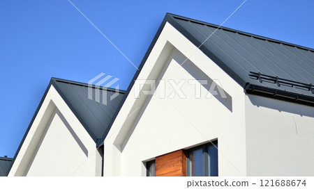 Terraced family homes in newly developed housing estate. The real estate market in the suburbs. New single family houses in a new development area. Residential homes with modern facade.  121688674