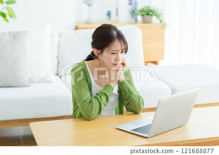 Young woman working on a laptop at home Young woman working on a laptop at home 121688877