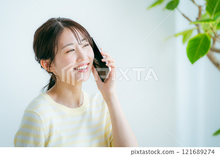 在房間裡操作智能手機的女人 121689274