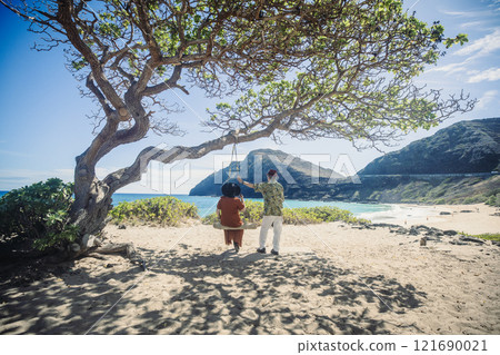 夏威夷東海岸海灘上,一對老夫婦坐在樹下的鞦韆上眺望大海。 夏威夷東海岸海灘上,一對老夫婦坐在樹下的鞦韆上眺望大海。 121690021