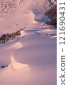 Snow cornice at sunrise 121690431