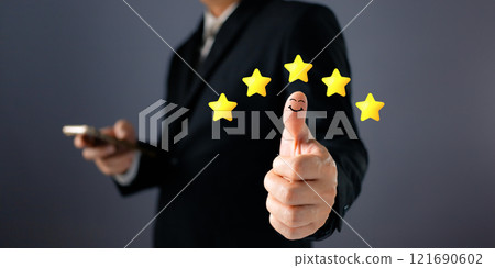 Customer service and poll concept. a businessman thumbs up on the happy smile icon and five star to give satisfaction in service.rating very impressed. Customer service and poll concept. a businessman thumbs up on the happy smile icon and five star to give satisfaction in service.rating very impressed. 121690602