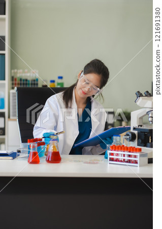 Female biotechnologist testing new chemical substances in a laboratory. Female biotechnologist testing new chemical substances in a laboratory. 121691380