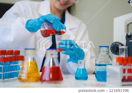 Female biotechnologist testing new chemical substances in a laboratory. 121691396
