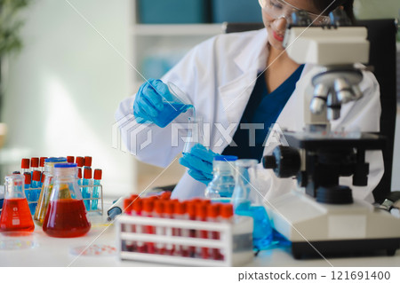 Female biotechnologist testing new chemical substances in a laboratory. Female biotechnologist testing new chemical substances in a laboratory. 121691400