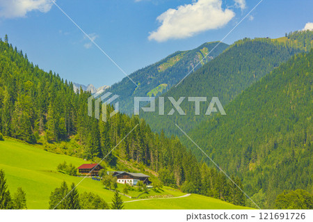 Wonderful wooded mountain alpine panorama with village and huts Austria. Wonderful wooded mountain alpine panorama with village and huts Austria. 121691726