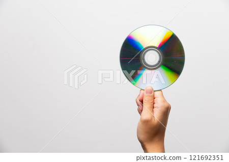 Hand holding CD or DVD disc against light on white background. Data erasure, old digital media, rarity Hand holding CD or DVD disc against light on white background. Data erasure, old digital media, rarity 121692351