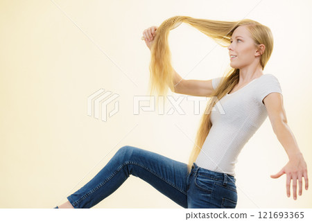 Blonde girl brushing her long hair Blonde girl brushing her long hair 121693365