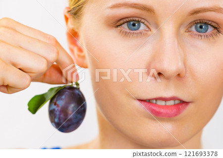 Girl holds plum fruit 121693378