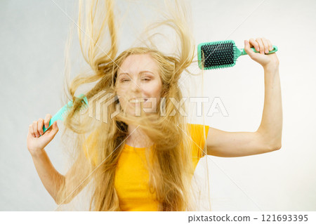 Girl blowing hair with comb brush 121693395