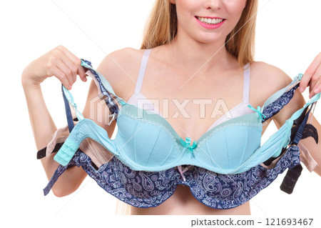 Female holds bras. Bra fitting 121693467