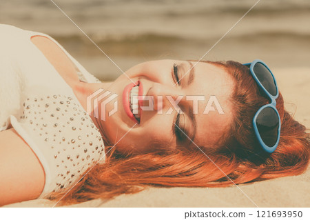 Redhaired happy girl on beach. 121693950