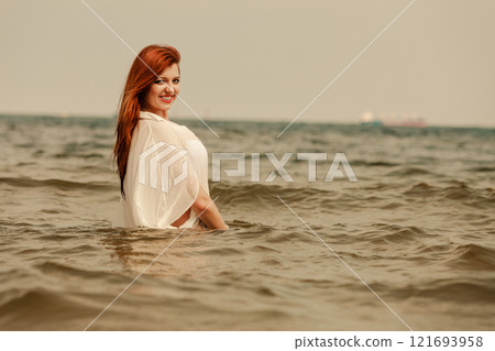 Redhaired happy girl on beach. Redhaired happy girl on beach. 121693958