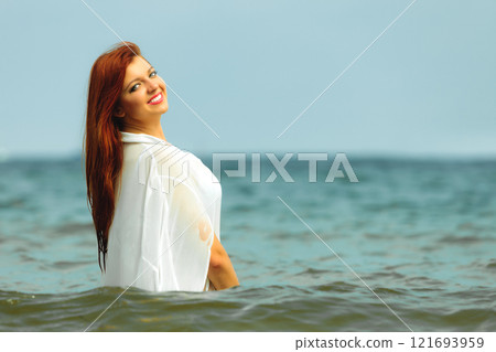 Redhaired happy girl on beach. 121693959