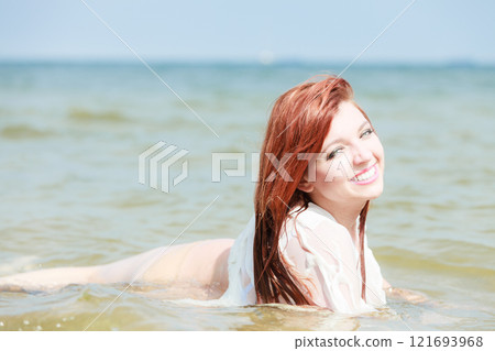 Redhaired happy girl on beach. 121693968