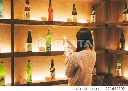 選擇清酒的年輕女性[攝影合作：新潟當地清酒優質SAKE Kura KURA] 121694202