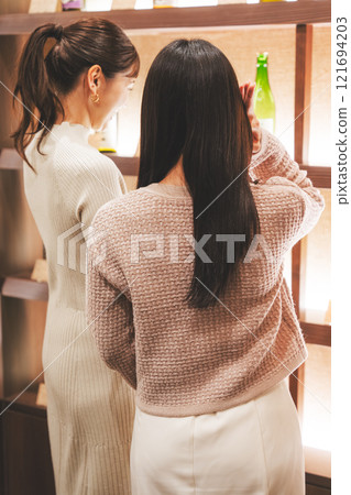 選擇清酒的年輕女性[攝影合作：新潟當地清酒優質SAKE Kura KURA] 121694203