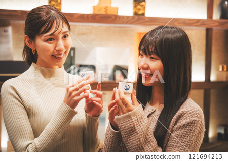 A young woman tasting sake [Photo courtesy of Niigata Jizake Premium SAKE Kura KURA] 121694213