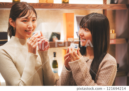 A young woman tasting sake [Photo courtesy of Niigata Jizake Premium SAKE Kura KURA] 121694214