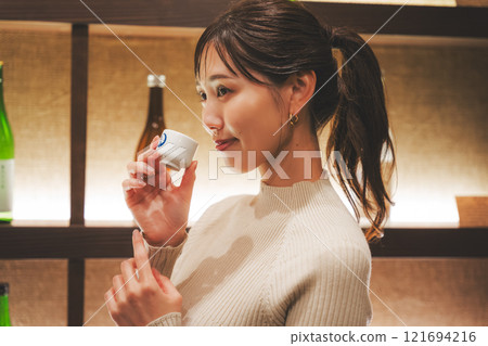 品嚐日本清酒的年輕女子[照片合作：新潟當地清酒特級SAKE Kura KURA] 121694216
