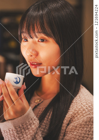品嚐日本清酒的年輕女子[照片合作：新潟當地清酒特級SAKE Kura KURA] 121694224