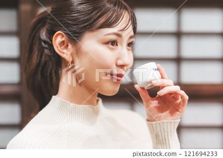 品嚐日本清酒的年輕女子[照片合作：新潟當地清酒特級SAKE Kura KURA] 121694233