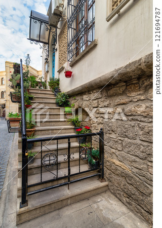 Stairs adorned with plants in the historic Icherisheher district of Baku, Azerbaijan under a cloudy sky Stairs adorned with plants in the historic Icherisheher district of Baku, Azerbaijan under a cloudy sky 121694787