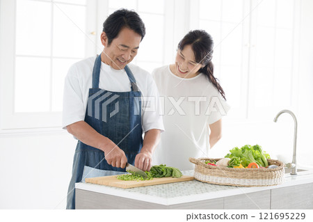 一對 50 多歲的夫婦在廚房享受烹飪的樂趣 - 丈夫的節日烹飪 121695229