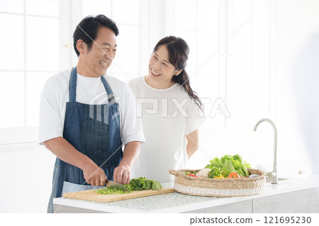 一對 50 多歲的夫婦在廚房享受烹飪的樂趣 - 丈夫的節日烹飪 121695230