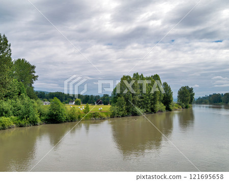 A picturesque riverside scene with a white church on the shore. 121695658