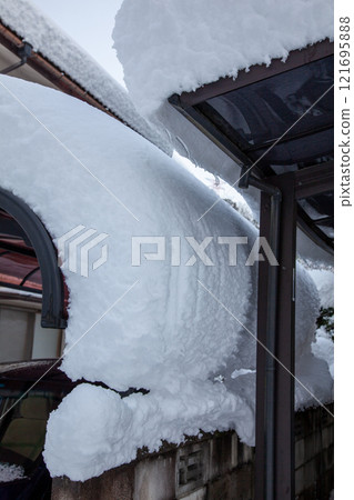 雪即將從車庫屋頂落下 雪即將從車庫屋頂落下 121695888