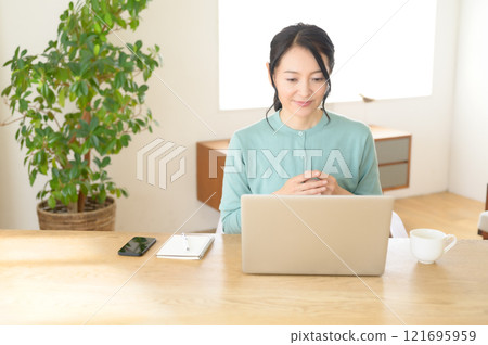 中年婦女一邊看電腦一邊思考 121695959