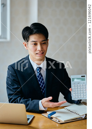 A young man in his 20s serving customers in an office 121696042
