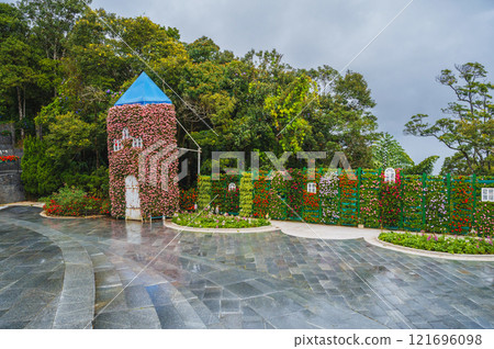 Picturesque view of the tower covered with live flowering plants 121696098