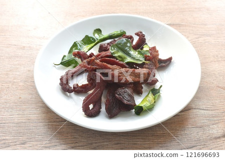 fried crispy salty fermenting beef meat with lemon leaf and chili on plate fried crispy salty fermenting beef meat with lemon leaf and chili on plate 121696693