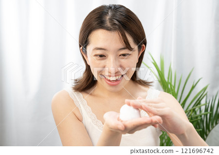A woman putting face wash foam on her hands A woman putting face wash foam on her hands 121696742