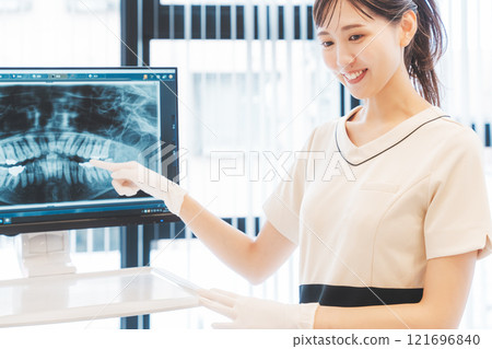A young woman explaining the condition of her teeth using an X-ray 121696840