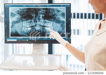 A young woman explaining the condition of her teeth using an X-ray 121696846
