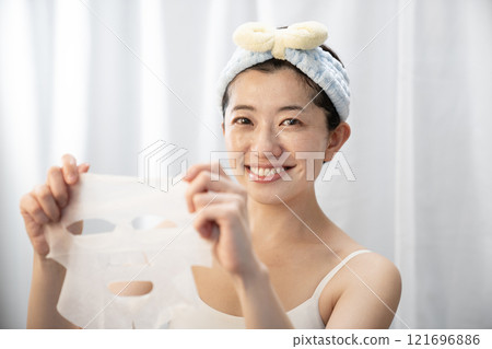 Smiling woman with a face pack 121696886