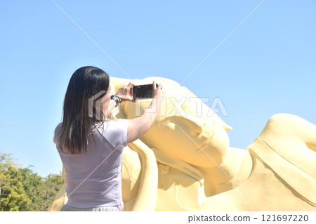 woman photo ancient reclining Buddha at Lokaya Sutha after renovate painting colors from white to yellow  121697220