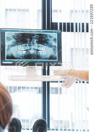 一位年輕女子用 X 光照片解釋她的牙齒狀況 一位年輕女子用 X 光照片解釋她的牙齒狀況 121697289