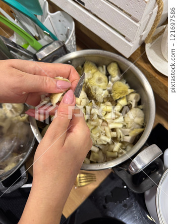 A woman is cleaning and washing mushrooms. Autumn mushrooms, Tricholoma Portentosum. A woman is cleaning and washing mushrooms. Autumn mushrooms, Tricholoma Portentosum. 121697586