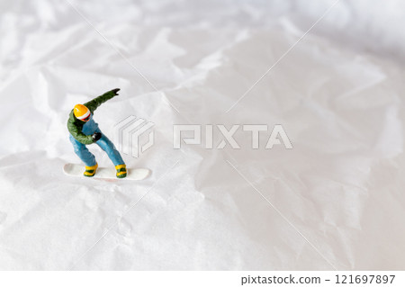 Miniature people  snowboarder dressed in vibrant winter gear, carving through a snowy slope 121697897