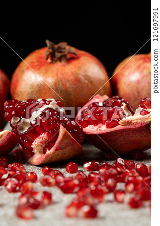 Ripe pomegranates, peeled and whole, the concept of benefits and vitamins in fruit. 121697991