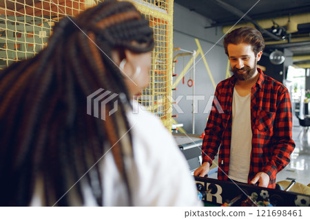 Black girl in a white t-shirt. Couple playing a table football Black girl in a white t-shirt. Couple playing a table football 121698461