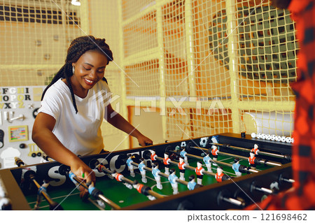 Black girl in a white t-shirt. Couple playing a table football 121698462