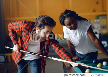 Black girl in a white t-shirt. Couple playing a billiard 121698466