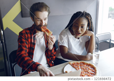Students create a new project. Couple working in a office. Black girl in a white t-shirt Students create a new project. Couple working in a office. Black girl in a white t-shirt 121698472
