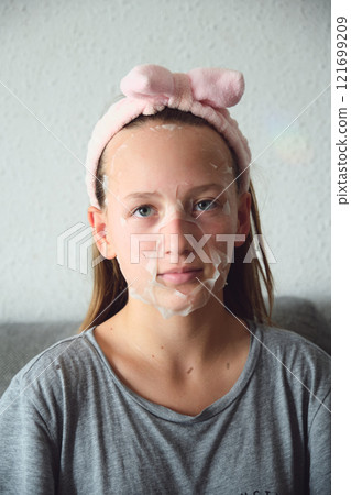 girl with a cosmetic mask on her face girl with a cosmetic mask on her face 121699209
