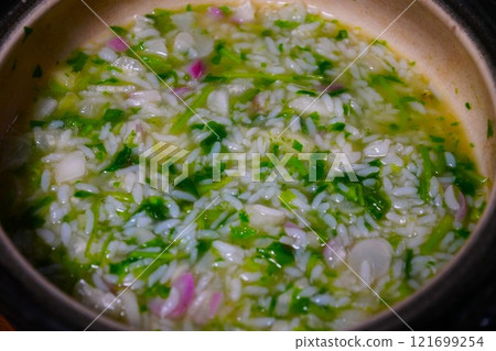 Rice porridge with seven herbs made in an earthenware pot Rice porridge with seven herbs made in an earthenware pot 121699254